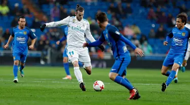 Pemain Real Madrid, Gareth Bale menggiring bola dengan kawalan pemain Fuenlabrada pada laga Copa del Rey 2017-2018 di Stadion Santiago Bernabeu, Selasa (28/11). Madrid lolos ke 16 besar Copa del Rey, meski imbang 2-2. (AP Photo/Francisco Seco)