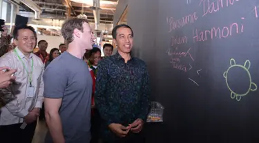 Mark Zuckerberg membaca pesan yang ditulis Presiden Jokowi di dinding saat berkunjung ke kantor Facebook di Silicon Valley, San Fransisco, Rabu (17/2). Dalam kunjungan itu Jokowi disambut langsung oleh CEO Facebook, Mark Zuckerberg. (Setpres/Biro Pers)