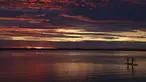 Dua orang menaiki stand up paddle saat matahari terbenam di danau Chiemsee di Chieming, Jerman, Selasa, (25/8/2020). Chiemsee adalah sebuah danau air tawar yang terletak di negara bagian Bayern, Jerman. (AP Photo / Matthias Schrader)