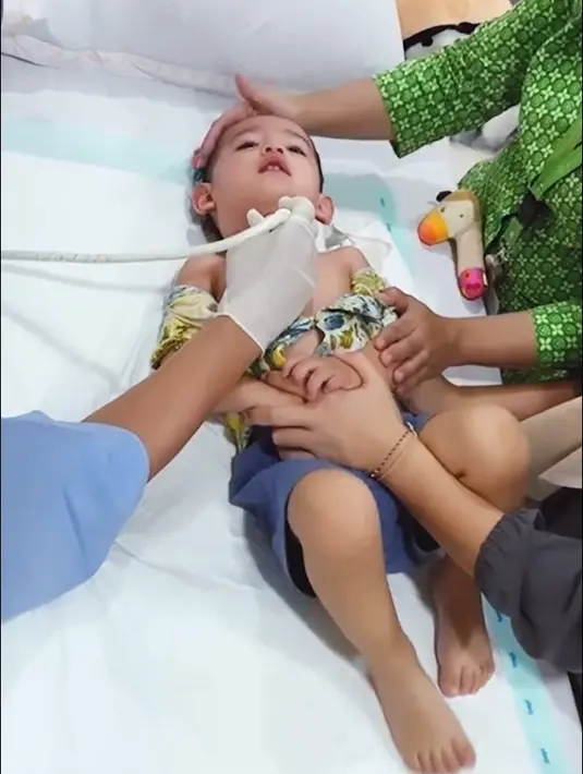 Setelah diperiksa, Jedar tampak mengendong sang buah hati sambil mendengarkan penjelasan dari dokter. Don mengidap limfadenitis atau pembesaran kelenjar getah bening. [Instagram/inijedar]