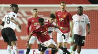 Amad Diallo dari Manchester United dan Brahim Diaz dari AC Milan memperebutkan bola selama pertandingan leg pertama babak 16 besar Liga Europa di Old Trafford di Manchester, Inggris, Kamis, 11 Maret 2021. (AP Foto / Dave Thompson)