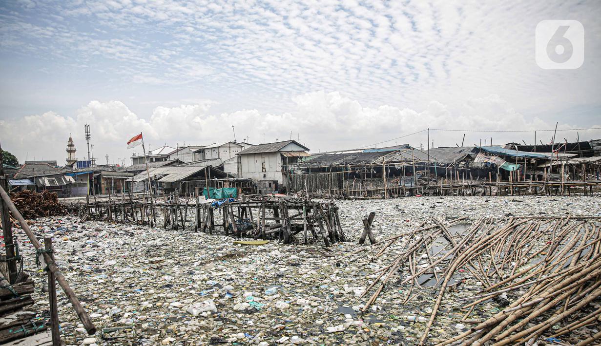 Suasana jembatan kayu di antara sampah di perkampungan nelayan Cilincing, Jakarta, Minggu (21/2/2022). Peringatan HPSN 2022, Pemprov DKI Jakarta mengajak warga Jakarta untuk peduli sampah mulai dari lingkungan terdekat minimal dengan cara memilah sampah dari rumah. (Liputan6.com/Faizal Fanani)