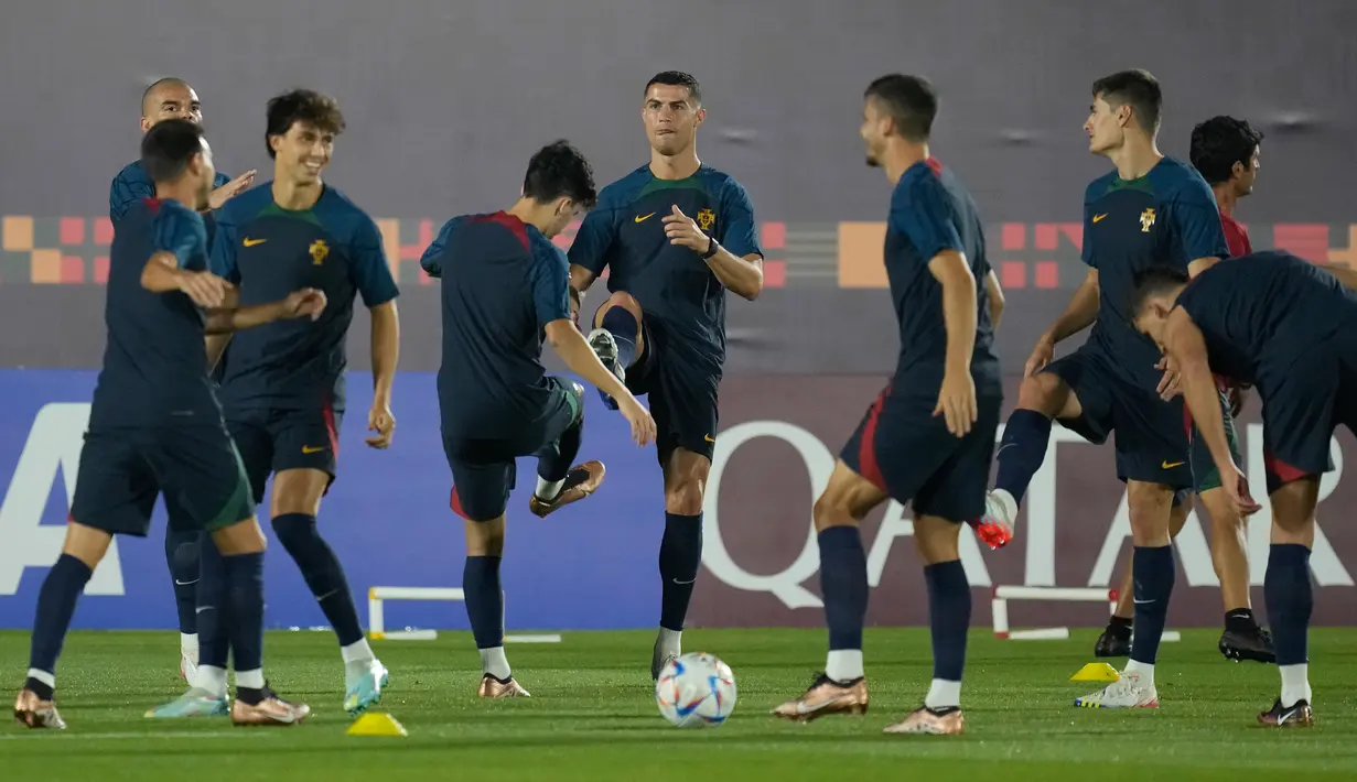 Cristiano Ronaldo (tengah) melakukan pemanasan dengan rekan satu timnya selama pelatihan resmi Portugal menjelang pertandingan sepak bola Piala Dunia grup H antara Portugal dan Ghana di tempat pelatihan Al Shahaniya SC, Al Shahaniya, Qatar, Rabu (23/11/2022). Dalam pertandingan nanti timnas Portugal akan berhadapan dengan Thomas Partey dan kawan-kawan. (AP Photo/Lee Jin-man)