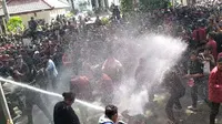 Massa unjuk rasa dihalau polisi dengan semprotan water canon di depan Gedung DPRD Malang. (Merdeka/Darmadi Sasongko)