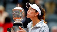 Petenis Prancis, Garbine Muguruza, mencium trofi Prancis Terbuka, seusai memenangi laga final melawan Serena Williams, Sabtu (4/6/2016). (EPA/Ettienne Laurent)