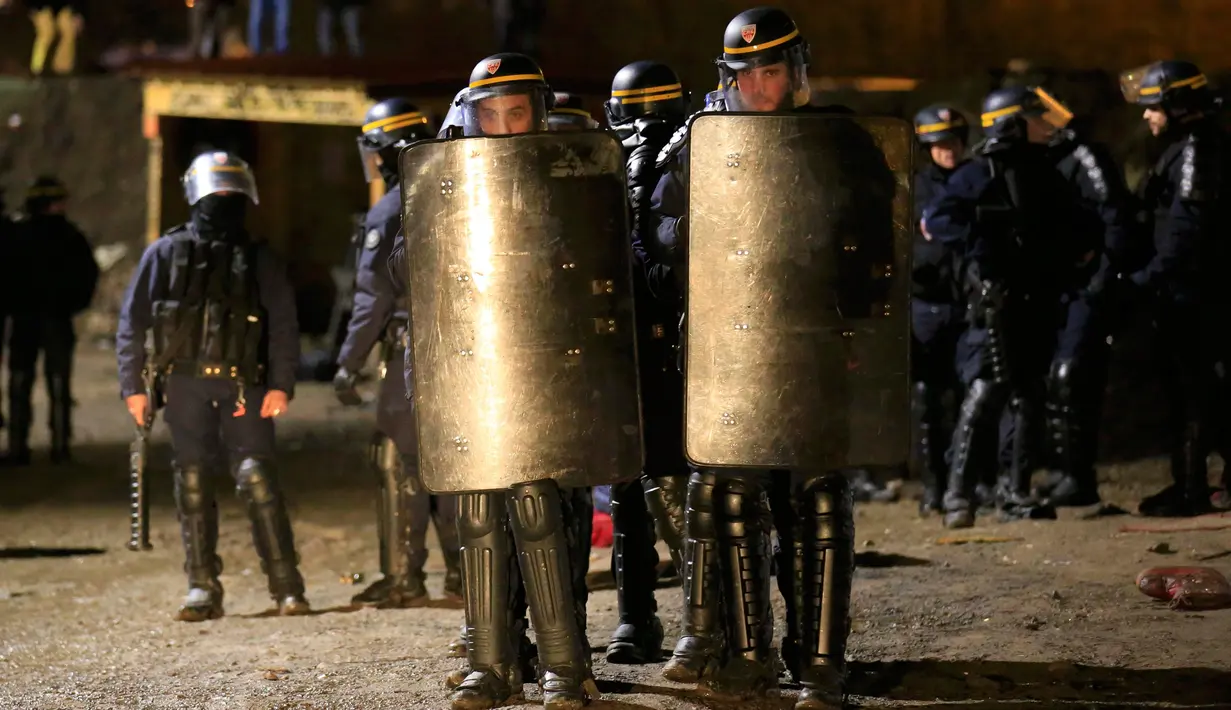 Polisi anti huru hara Prancis berjaga saat pembokaran lahan kumuh yang dijuluki "Jungle" di Calais, Prancis (1/3). Pembakaran ini memunculkan protes bagi ribuan imigran yang tinggal di lokasi tersebut. (REUTERS/Pascal Rossignol
