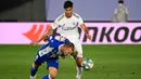 Gelandang Real Madrid, Marco Asensio (kanan) berebut bola dengan bek Alaves, Rodrigo Ely pada lanjutan Liga Spanyol di stadion Alfredo di Stefano, Sabtu (11/7/2020). Real Madrid menang 2-0 lewat gol Karim Benzema dan Marco Asensio. (GABRIEL BOUYS/AFP)