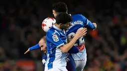 Gelandang Barcelona, Aleix Vidal berebut bola dengan bek Espanyol Mario Hermoso dan Aron Martin pada laga leg kedua perempat final Copa del Rey di Camp Nou, Kamis (25/1). Barcelona memetik kemenangan dua gol tanpa balas atas lawannya. (AP/Manu Fernandez)