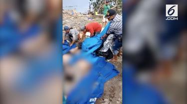 Petugas TNI, Basarnas, dan masyarakat mengevakuasi puluhan jenazah di kawasan Pantai Talise Palu