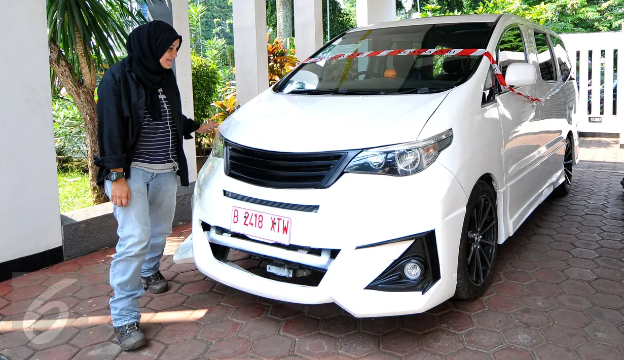 Wartawan melihat salah satu mobil listrik yang terparkir di Gedung Kejaksaan Agung, Jakarta, Rabu (24/6). Penyidik Kejagung menyita 10 mobil listrik hasil pengadaan proyek gagal yang digagas mantan Menteri BUMN Dahlan Iskan. (Liputan6.com/Yoppy Renato)
