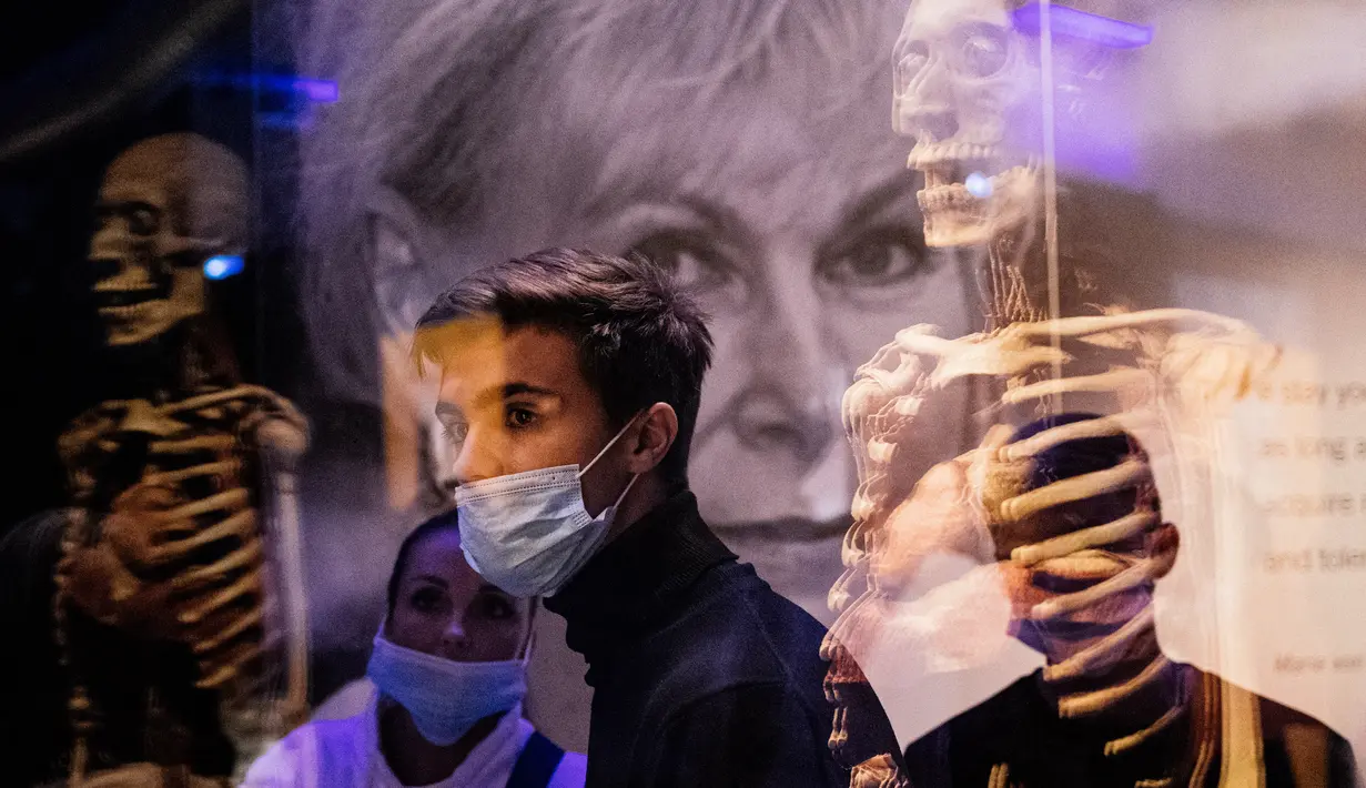 Pengunjung melihat salah satu karya seni yang dipajang dalam pameran anatomi tubuh manusia bertajuk 'Body Worlds' di Moskow, Rusia (24/3/2021). Banyak kelompok agama konservatif dan tokoh masyarakat yang kemudian mencekal pameran ini. (AFP/Dimitar Dilkoff)