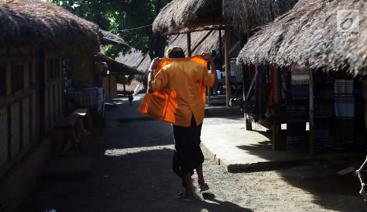 Menyusuri tanah tak beraspal saat memasuki perkampungan berdiri kokoh  rumah adat beratap ilalang. Sepanjang mata memandang nampak para pemilik rumah tengah sibuk menenun kain khas setempat. (Liputan6.com/Angga Yuniar)