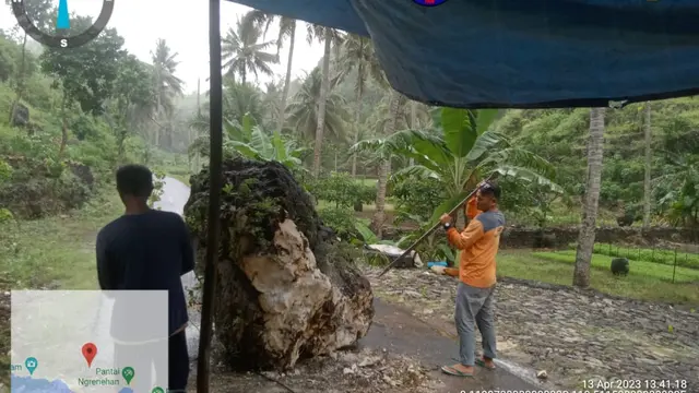 Petugas Sar dan Relawan memecahkan batu yang berada ditengah jalan menuju Pantai Ngrenehan