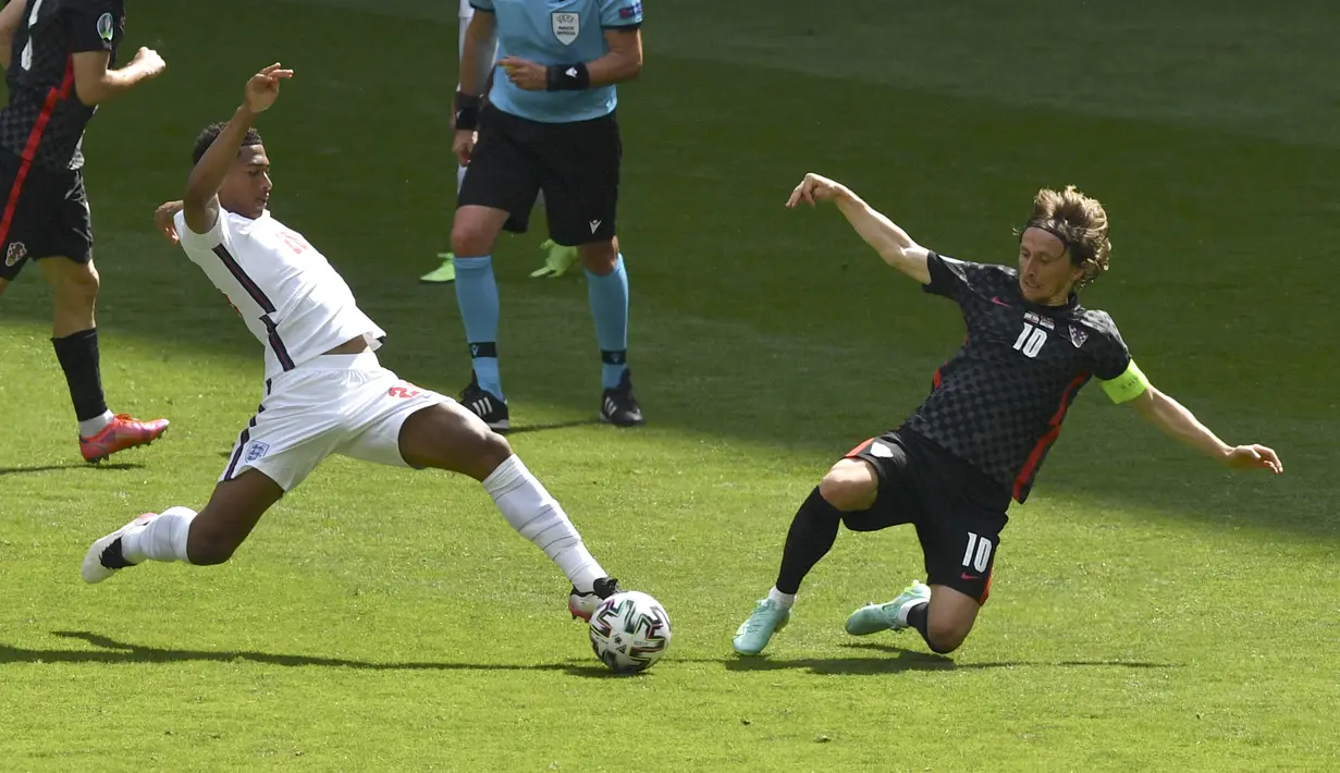 Gelandang Kroasia, Luka Modric (kanan) berebut bola dengan gelandang Inggris, Jude Bellingham pada pertandingan grup D Euro 2020 di stadion Wembley di London, Minggu (13/6/2021). Dengan kemenangan ini,  Inggris bertengger di peringkat pertama grup D. (AP Photo/Justin Tallis, Pool )
