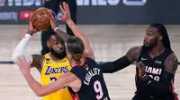 Pebasket Los Angeles Lakers, LeBron James, berusaha melewati pebasket Miami Heat pada gim pertama final NBA di Lake Buena Vista, Kamis (1/10/2020). Lakers menang dengan skor 116-98. (AP Photo/Mark J. Terrill)
