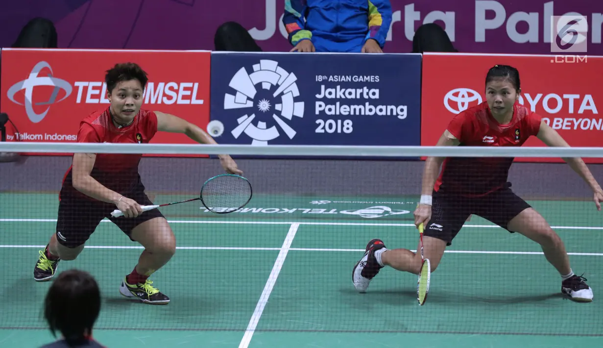 Ganda putri Indonesia, Greysia Polii/Apriyani Rahayu mengembalikan kok ke arah pemain Jepang, Yuki Fukushima/Sayaka Hirota pada semifinal Bulutangkis Beregu Putri Asian Games 2018 di Jakarta, Selasa (21/8). (Liputan6.com/Helmi Fithriansyah)