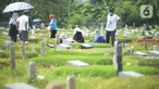 Warga berdoa saat melakukan ziarah di area pemakaman khusus COVID-19 di TPU Rorotan, Cilincing, Jakarta Utara, Rabu (4/5/2022). Sejumlah tempat pemakaman umum masih dipadati oleh keluarga yang melakukan ziarah di H+3 Lebaran. (merdeka.com/Imam Buhori)