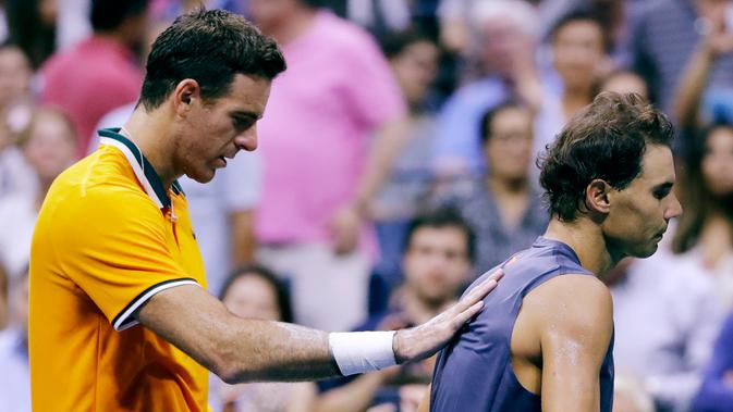 Petenis Spanyol, Rafael Nadal berjalan menjauh dari Juan Martin del Potro (Argentina) setelah mengundurkan diri pada semifinal AS Terbuka 2018, Jumat (7/9). Ini kedua kalinya pada tahun ini Nadal mengundurkan diri dari kejuaraan Grand Slam (AP/Seth Wenig)