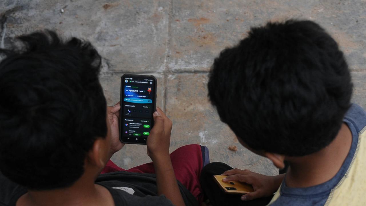 Dua orang anak sedang melakukan pesanan makanan secara daring digital dengan aplikasi Gopay di Desa Kubang, Kabupaten Bogor, Jawa Barat, Sabtu (17/2/2024). Foto: merdeka.com / Imam Buhori