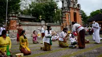 Umat Hindu berdoa untuk merayakan Hari Raya Galungan di Pura Jagat Natha di Denpasar, di pulau Bali (16/9/2020). Galungan dirayakan umat Hindu di Bali sebagai hari kemenangan Dharma (Kebaikan) melawan Adharma (Keburukan). (AFP Photo/Sonny Tumbelaka)