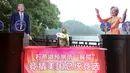 Seekor monyet mengenakan kaos bertuliskan "Raja Prediksi" duduk di antara foto calon presiden AS Donald Trump dan Hillary Clinton saat berusaha memprediksi hasil Pilpres AS 2016, di Changsha, Provinsi Hunan, China, Kamis (3/11). (REUTERS/Stringer)