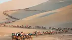 Para wisatawan menaiki unta di padang pasir di Dunhuang di provinsi Gansu di China barat laut (10/8/2019). Dunhuang adalah sebuah kota tingkat kabupaten di barat laut provinsi Gansu, Tiongkok Barat. (AFP Photo/Str)