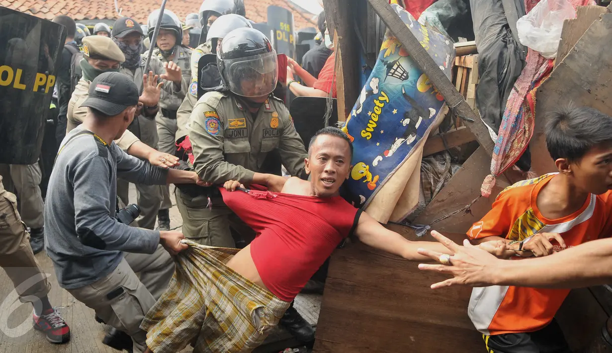 Aparat keamanan melakukan aksi membawa paksa warga yang mencoba bertahan saat penggusuran Pasar Ikan, Penjaringan, Jakarta, Senin (11/4). Bentrokan terjadi antara petugas dan warga yang menolak penggusuran di kawasan tersebut (Liputan6.com/Gempur M Surya)