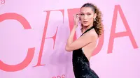 Model Bella Hadid berpose saat menghadiri CFDA Fashion Awards di Brooklyn Museum of Art, New York City (3/6/2019). Bella Hadid tampil seksi mengenakan gaun halter berpayet hitam backless dari Michael Kors Collection dengan hiasan bulu. (AFP Photo/Dimitrios Kambouris)