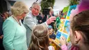 Pangeran Charles bersama istri Camilla Parker memberi sentuhan akhir pada lukisan anak-anak di Brisbane, Australia, Rabu (4/4). Keduanya menunjungi Australia untuk menghadiri pembukaan Gold Coast Commonwealth Games 2018. (Patrick HAMILTON/POOL/AFP)