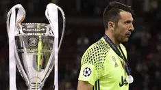 Kiper Juventus, Gianluigi Buffon, tampak sedih ketika melewati piala Liga Champions di Stadion Millennium, Sabtu (3/6/2017). Juventus kalah 1-4 dari Real Madrid. (AFP/Javier Soriano)