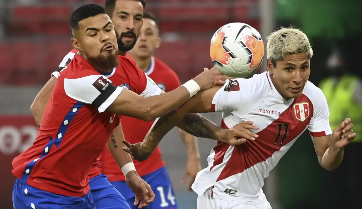 Bek Chile, Paulo Diaz dan penyerang peru, Raul Ruidiaz berebut bola dalam laga Kualifikasi Piala Dunia 2022 zona Conmebol di Estadio Nacional, Santiago, Jumat (13/11/2020). Chile mengalahkan Peru 2-0 berkat gol yang diborong Arturo Vidal. (Martin BERNETTI / POOL / AFP)