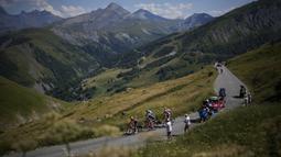 Pebalap tim Ineos Grenadiers, Thomas Pidcock (kiri) memimpin rombongan saat Stage 12 Tour de France 2022 yang menempuh rute sepanjang 165,1 km dari Briancon hingga L'Alpe-d'Huez, di Pegunungan Alpen, Prancis, Jumat (14/07/2022). (AP/Thibault Camus)