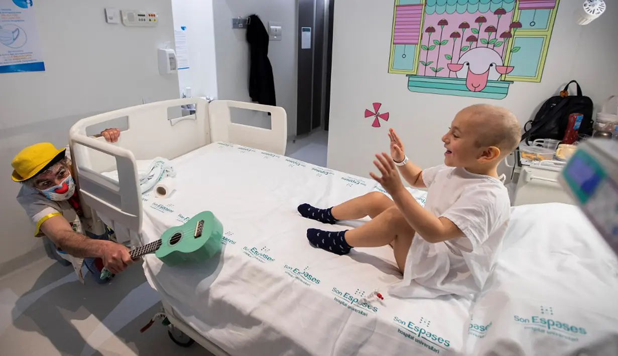 Badut dari LSM Sunrise Media (Senyuman Medis) tampil untuk pasien berusia empat tahun Emilyn di sayap anak-anak Rumah Sakit Son Espases, Palma de Mallorca, Spanyol, 8 Maret 2021. (JAIME REINA/AFP)