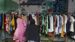 Bantuan yang dibagikan berupa pakaian layak pakai dan bahan makanan yang berasal dari sumbangan warga sekitar. Tampak dalam foto, warga memilih pakaian layak pakai yang dibagikan secara cuma-cuma di permukiman RT 02/RW 04 kawasan Jati Padang, Jakarta, Jumat (6/3/2026). (merdeka.com/Arie Basuki)