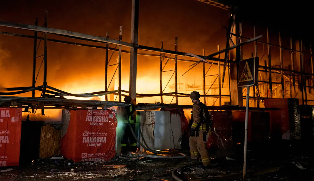 Petugas pemadam kebakaran Layanan Darurat Negara Ukraina berusaha memadamkan api setelah penembakan Rusia menghantam sebuah pusat perbelanjaan di Kherson, Ukraina, 3 Februari 2023. Asap membumbung tinggi dari pusat perbelanjaan yang terbakar setelah serangan Rusia ke pusat perbelanjaan tersebut. (AP Photo/LIBKOS)