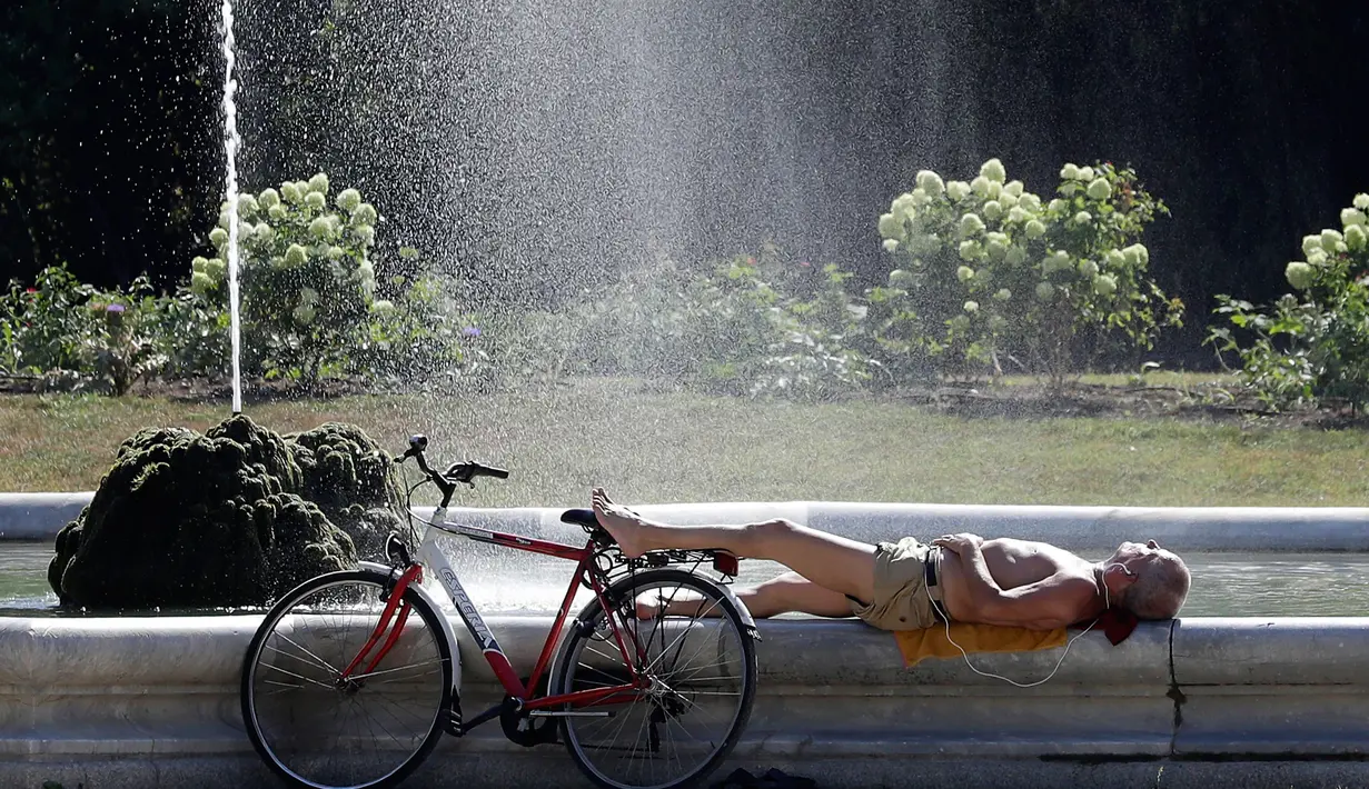 Seorang pria menyegarkan diri di air mancur di pusat kota Milan, Italia, 2 Agustus 2017. Suhu diperkirakan mencapai 35-40 derajat celcius (95-104 Fahrenheit) di Italia tengah dan selatan. (AP Photo / Antonio Calanni)