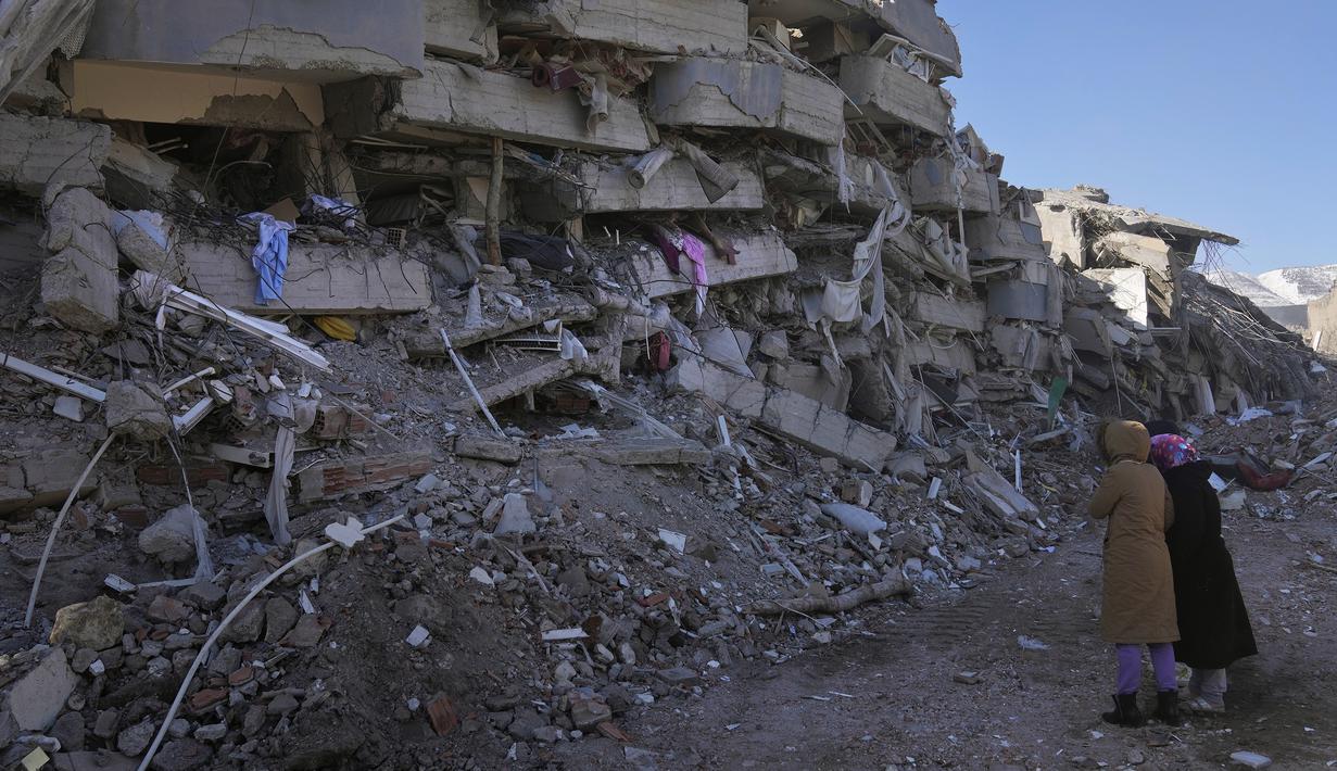 Wanita dari Turki memeriksa bangunan mereka yang hancur, di Kahramanmaras, Turki selatan, Rabu, 8 Februari 2023. Dengan harapan menemukan korban selamat memudar, tim penyelamat yang membentang di Turki dan Suriah pada Rabu masih mencari tanda-tanda kehidupan di antara puing-puing ribuan bangunan yang roboh akibat gempa paling mematikan di dunia dalam lebih dari satu dekade. (AP Photo/Hussein Malla)