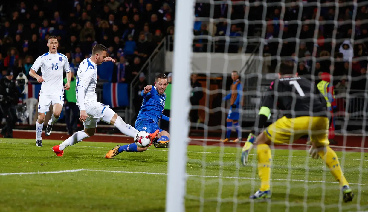 Pemain Islandia, Gylfi Sigurdsson melakukan tendangan ke gawang Kosovo pada laga Grup I Kualifikasi Piala Dunia 2018 di Laugardalsvollur, Senin (9/10). Islandia lolos ke Piala Dunia untuk pertama kalinya setelah menang 2-0. (AP/Brynjar Gunnarsson)
