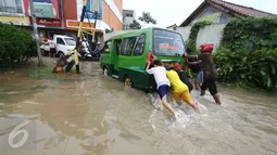 Warga mendorong angkot yang mogok saat banjir di jalan Merpati Raya kota,Tangerang Selatan, Selasa (21/2). Intensitas curah hujan yang tinggi di sertai buruknya Drainase menyebabkan banjir 50-100 cm di kawasan tersebut. (Liputan6.com/Helmi Afandi)