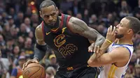 Pemain Cleveland, LeBron James (kiri) mencoba melewati adangan pemain Warriors, Stephen Curry pada gim ketiga final NBA basketball di Quicken Loans Arena, (6/6/2018). Warriors kalahkan Cavaliers 110-102. (Joshua Gunter/The Plain Dealer via AP)