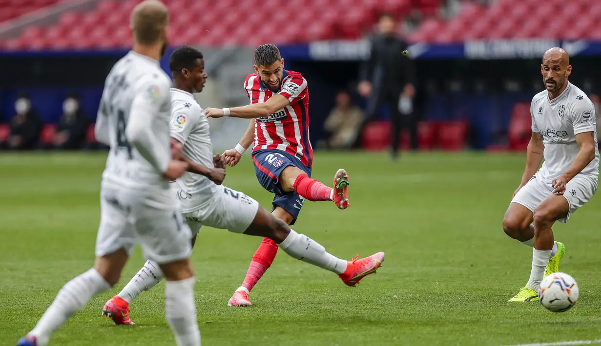 Gelandang Atletico Madrid, Yannick Carrasco (tengah) melepaskan tendangan ke gawang SD Huesca dalam laga lanjutan Liga Spanyol 2020/2021 pekan ke-32 di Wanda Metropolitano Stadium, Madrid, Kamis (22/4/2021). Atletico menang 2-0 atas SD Huesca. (AP/Manu Fernandez)