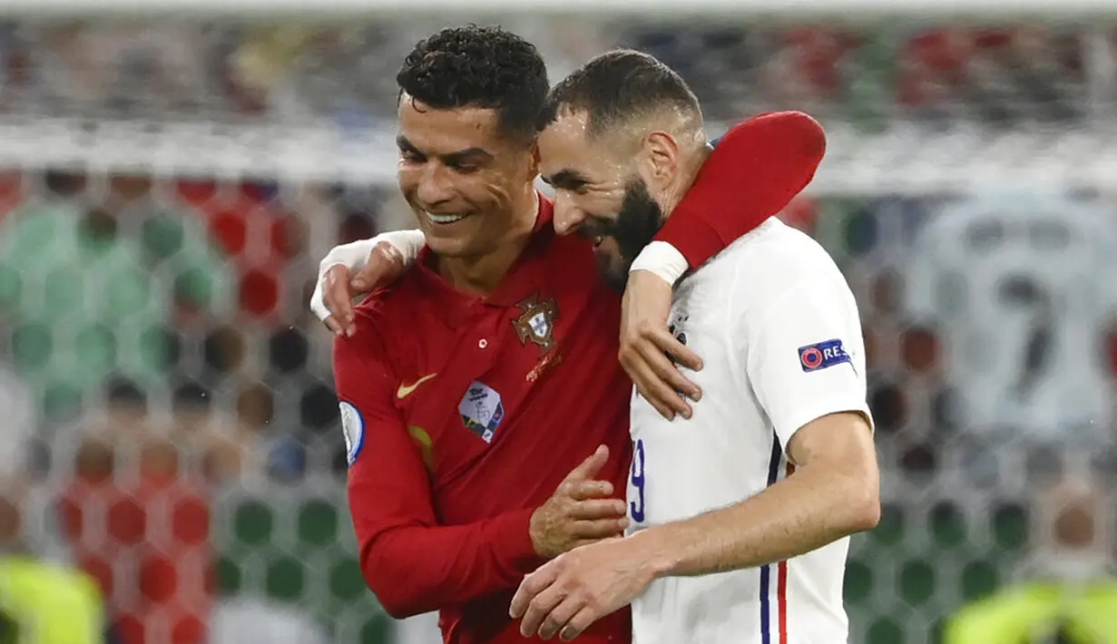 Pemain Portugal Cristiano Ronaldo (kiri) dan pemain Prancis Karim Benzema (kanan) meninggalkan lapangan bersama saat turun minum pada pertandingan Grup F Euro 2020 di Puskas Arena, Budapest, Hungaria, Rabu (23/6/2021). Laga berakhir imbang 2-2. (Franck Fife, Pool photo via AP)