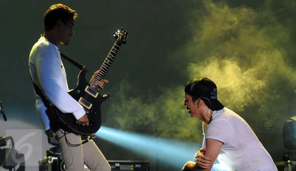 Vokalis grup band NOAH, Ariel melihat permainan gitaris, Loekman Hakim saat tampil usai perhelatan Achilles Motorsport Festival 2015 di JIExpo Kemayoran Jakarta, Sabtu (19/12/2015). (Liputan6.com/Helmi Fithriansyah)