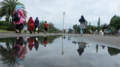 Sejumlah pengunjung berjalan saat sedang liburan di Monumen Nasional (monas), Jakarta, Selasa (25/12). Liburan Natal 2018, banyak warga datang bersama kerabat maupun keluarga memadati Monas. (Liputan6.com/Herman Zakharia)