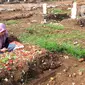 Warga melakukan ziarah makam menyambut bulan Ramadhan 1442 H di Tempat Pemakaman Umum (TPU) khusus covid-19 di Srengseng sawah 2, Jakarta Selatan, Jumat (09/04/2021). Tradisi ziarah makam dalam menyambut bulan Ramadhan setiap tahun dilakukan oleh umat Islam.
(merdeka.com/Arie Basuki)