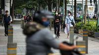 Sejumlah pekerja berjalan usai bekerja di Jalan Jenderal Sudirman, Jakarta, Selasa (10/5/2022). Pemerintah mengimbau masyarakat menerapkan bekerja dari rumah atau work from home (WFH) selama satu hingga dua pekan ke depan untuk mengantisipasi penyebaran virus corona COVID-19 usai libur Lebaran 2022. (Liputan6.com/Faizal Fanani)