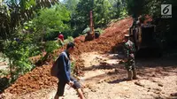 Petugas melakukan pengurukan material longsor di ruas Ciwidey-Cidaun, Kabupaten Cianjur, Jawa Barat (27/4). Dari tiga titik tersebut lokasinya berdekatan. Satu diantaranya tinggi timbunan tanah kurang lebih mencapai dua meter. (Liputan6.com/Ahmad Sudarno)