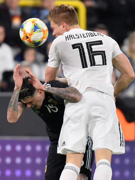 Pemain Timnas Jerman Marcel Halstenberg melompat saat berebut bola dengan pemain Timnas Argentina Rodrigo De Paul dalam laga persahabatan di Stadion Signal Iduna Park, Dortmund, Rabu (9/10/2019).  Menghadapi Argentina, Timnas Jermanharus puas bermain 2-2 dengan lawannya. (AP/Martin Meissner)