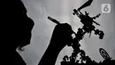 Staf Peran Serta Masyarakat dan Penataan Hukum (PSMPH) Sudin Lingkungan Hidup Jakarta Timur, Seto Krisna Putra menyelesaikan pembuatan miniatur robot dari sampah korek gas di Kantor Sudin Lingkungan Hidup Jakarta Timur, Minggu (20/2/2022). (merdeka.com/Iqbal S Nugroho)