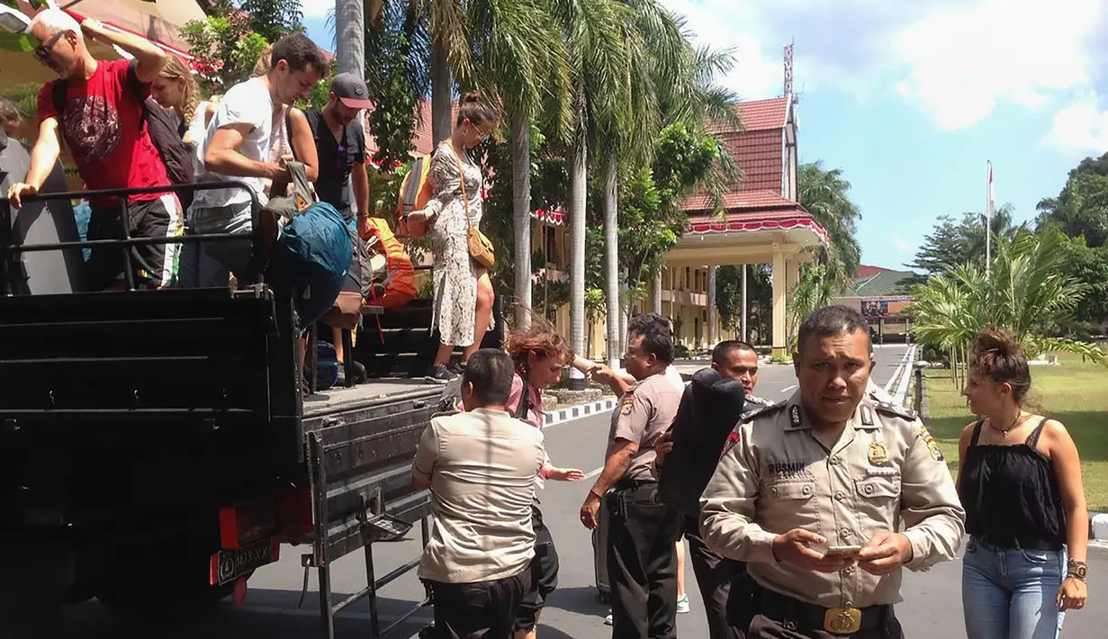 Wisatawan asing turun dari mobil saat akan meninggalkan Gili Trawangan, NTB, Senin (6/8). Gempa berkekuatan 6,9 skala Richter menewaskan 91 orang dan ratusan lainnya terluka. (Handout/Indonesia Water Police/AFP)
